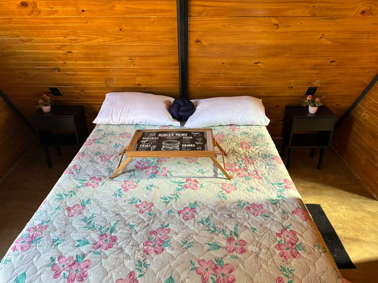 Cama do chalé preparada com bandeja de café da manhã