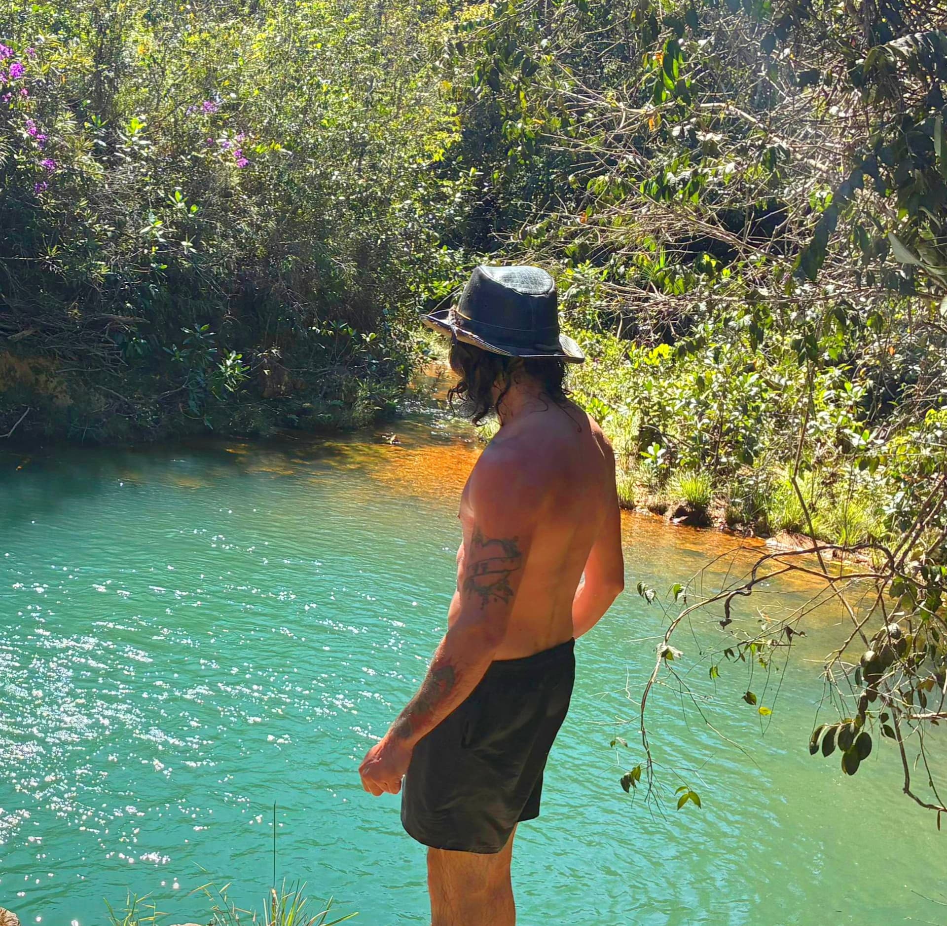Homem contemplando as águas verdes de um rio da Chapada dos Veadeiros